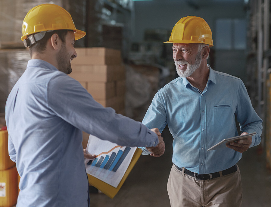 A Forklift Dealership Owner Shaking Hands with a Warehouse Customer